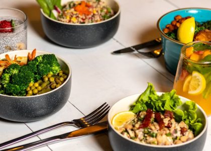A vibrant assortment of healthy bowls and drinks showcasing fresh ingredients like broccoli and citrus.